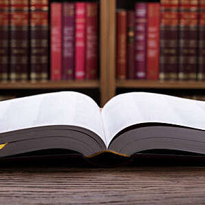 Close-up of an open law book on wooden desk.