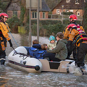 Family being rescued by the fire service after the River Derwent burst it