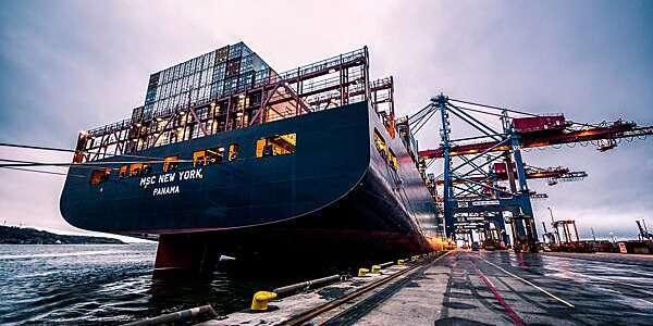 Vanishing perspective of container ship and docking area.